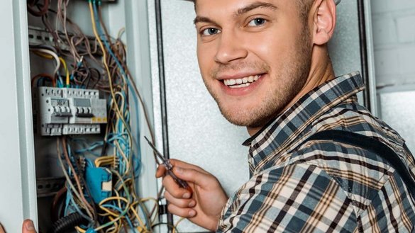 EIn Elektroniker der an einem Verteilerkasten arbeitet
