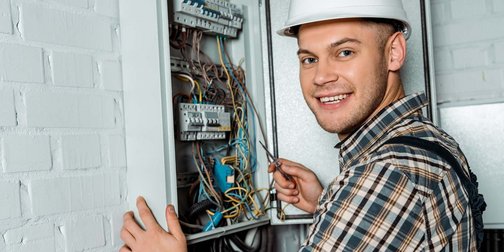 EIn Elektroniker der an einem Verteilerkasten arbeitet
